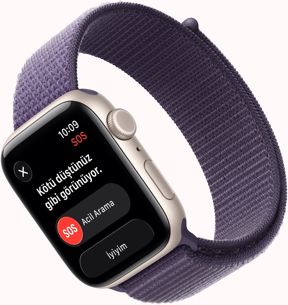 Apple Watch SE 3, alüminyum kasa, yıldız ışığı renk, SOS Düşme Algılama bildirimi, Acil Arama ve İyiyim düğmeleri, sağ dış görünüm, Digital Crown, mikrofon, yan düğme, kordon, Spor Loop, sis moru renk
