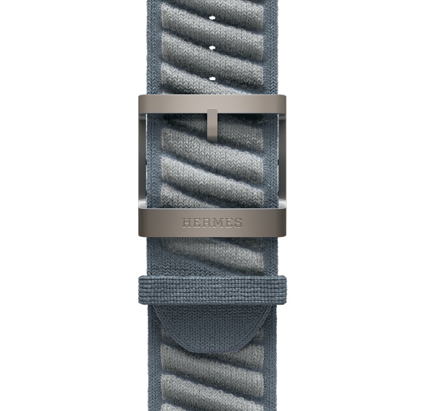Bracelet En Mer pour Apple Watch Hermès Ultra 3, bleu gris/bleu glacier (bleu gris avec rayures texturées diagonales gris clair), mailles tricotées en fil polyamide, trous d’ajustement centrés, boucle en titane finition naturelle gravée Hermès