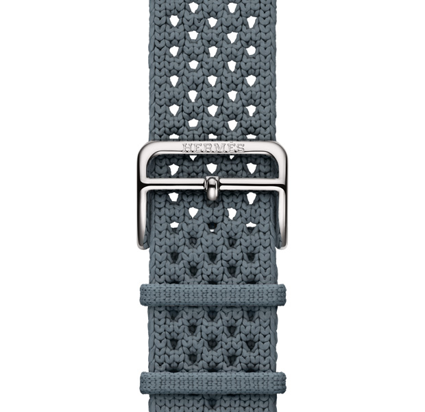 Bracelet Néo Tricot pour Apple Watch Hermès Series 11, bleu gris, mailles tricotées en fil polyamide, trous d’ajustement centrés, fermeture à boucle argent gravée Hermès