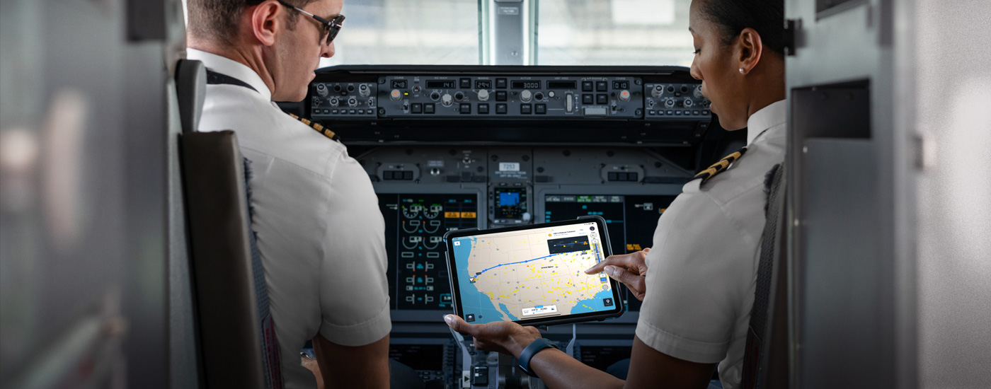 Kokpitte, bir iPad ekranındaki haritaya bakan iki pilot.