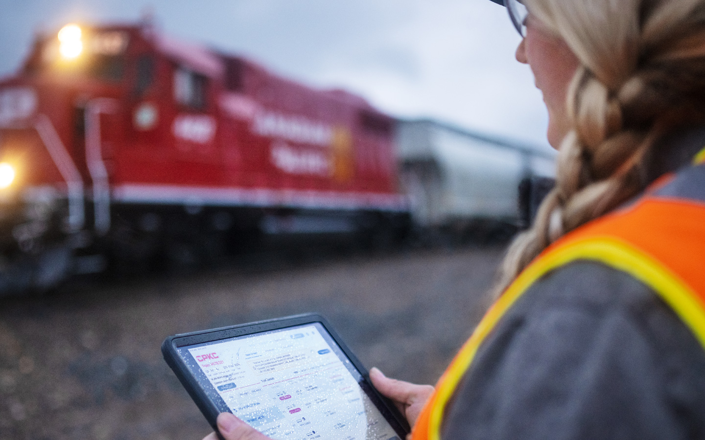 Une cheminote vérifie les horaires des trains sur un iPad dans une gare de triage